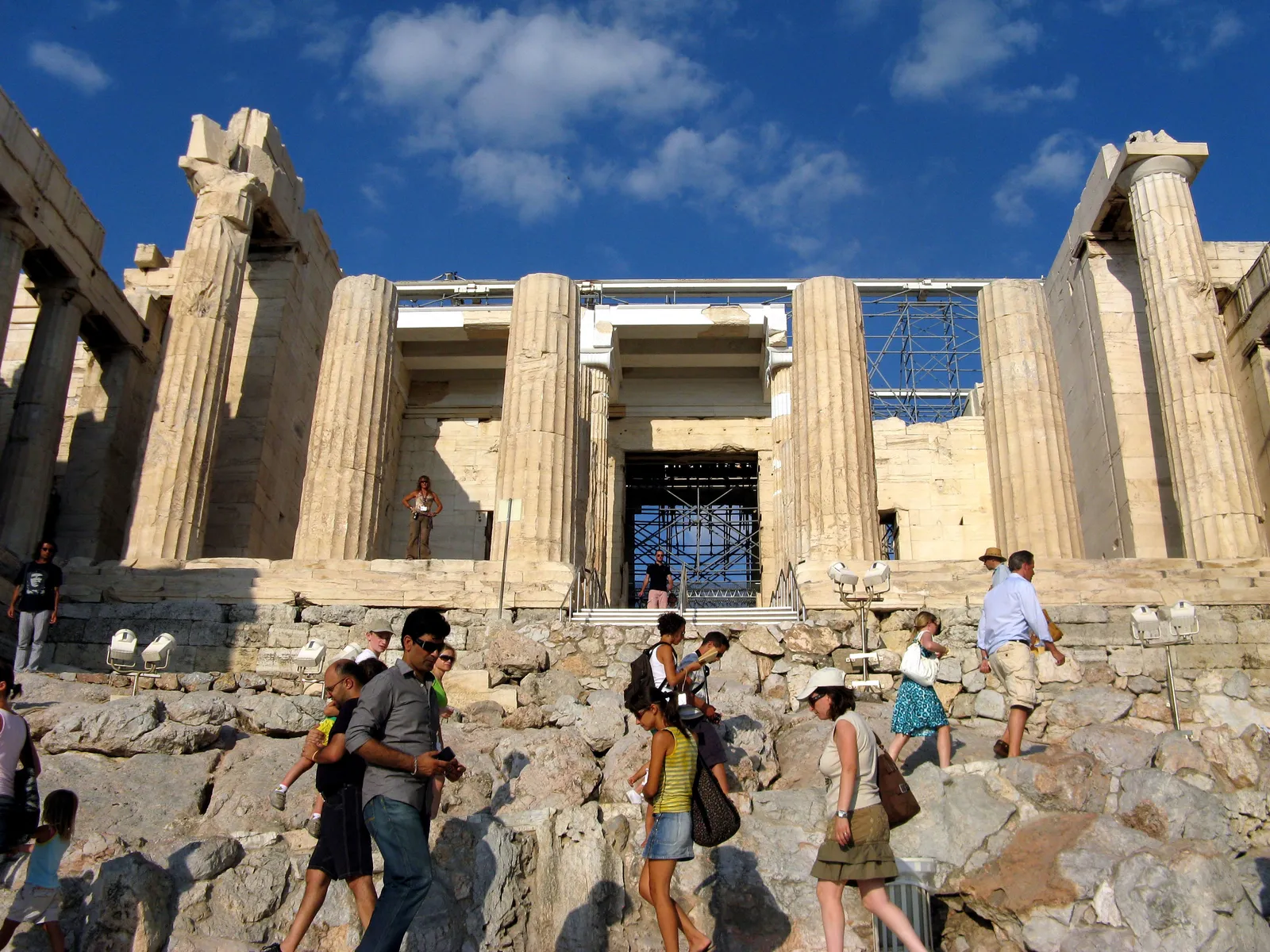 Visitors climbing the rock steps towards the columns of the Propylaea, the gateway building at the entrance to the Acropolis in Athens