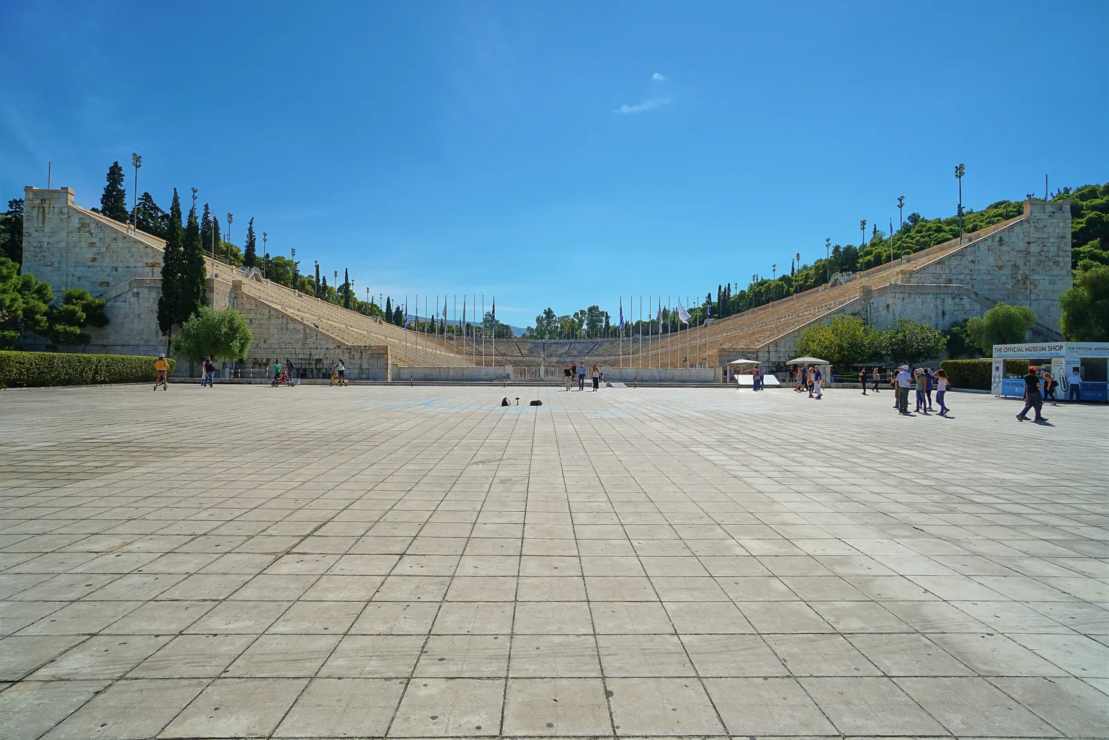 The white marble horseshoe of the Panathenaic Stadium in Athens seen from the open forecourt in front of its entrance