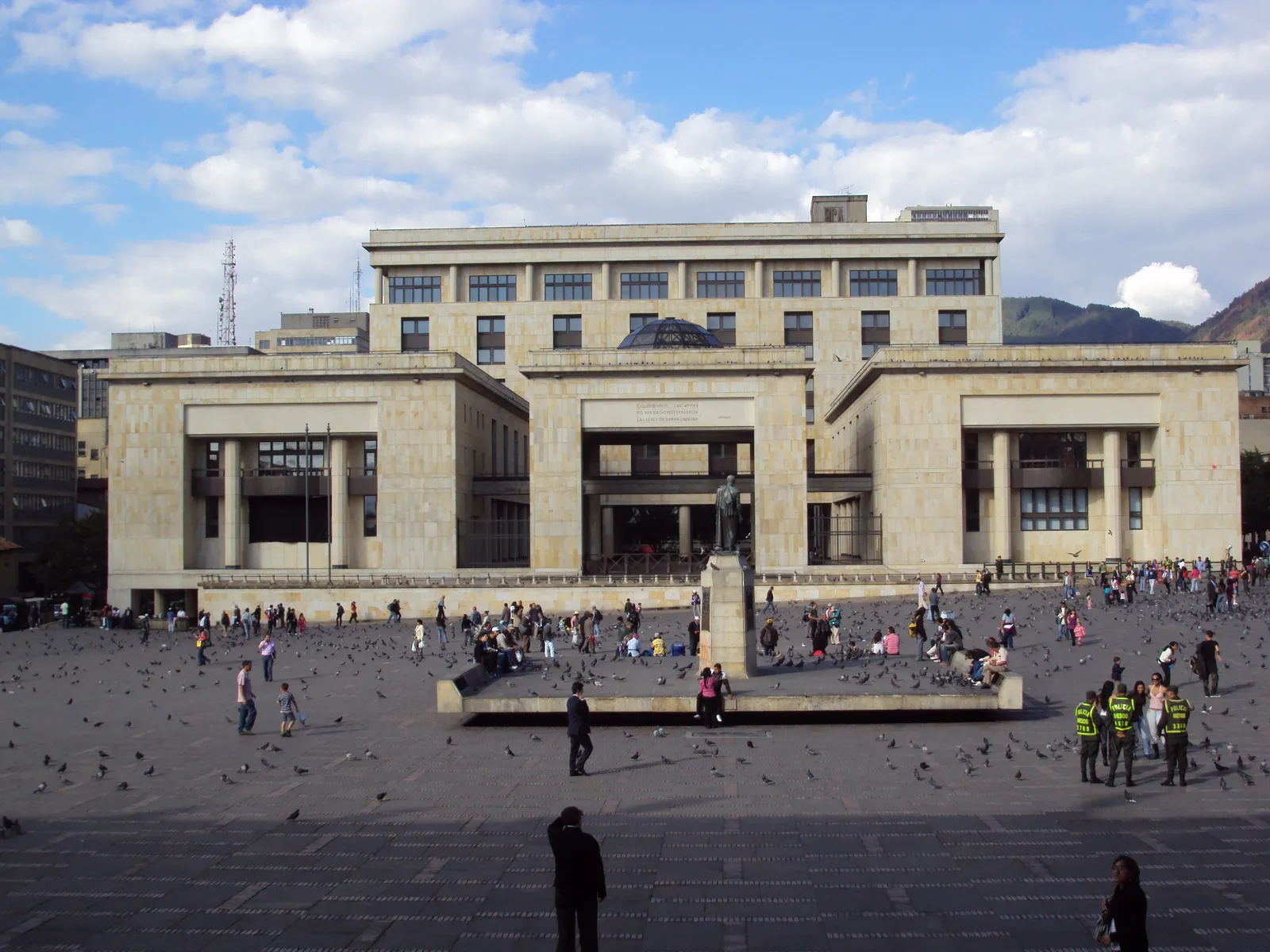 Plaza de Bolívar in Bogotá, a wide paved square full of pigeons and people with the pale stone Palace of Justice along its northern side and the Bolívar statue at the centre