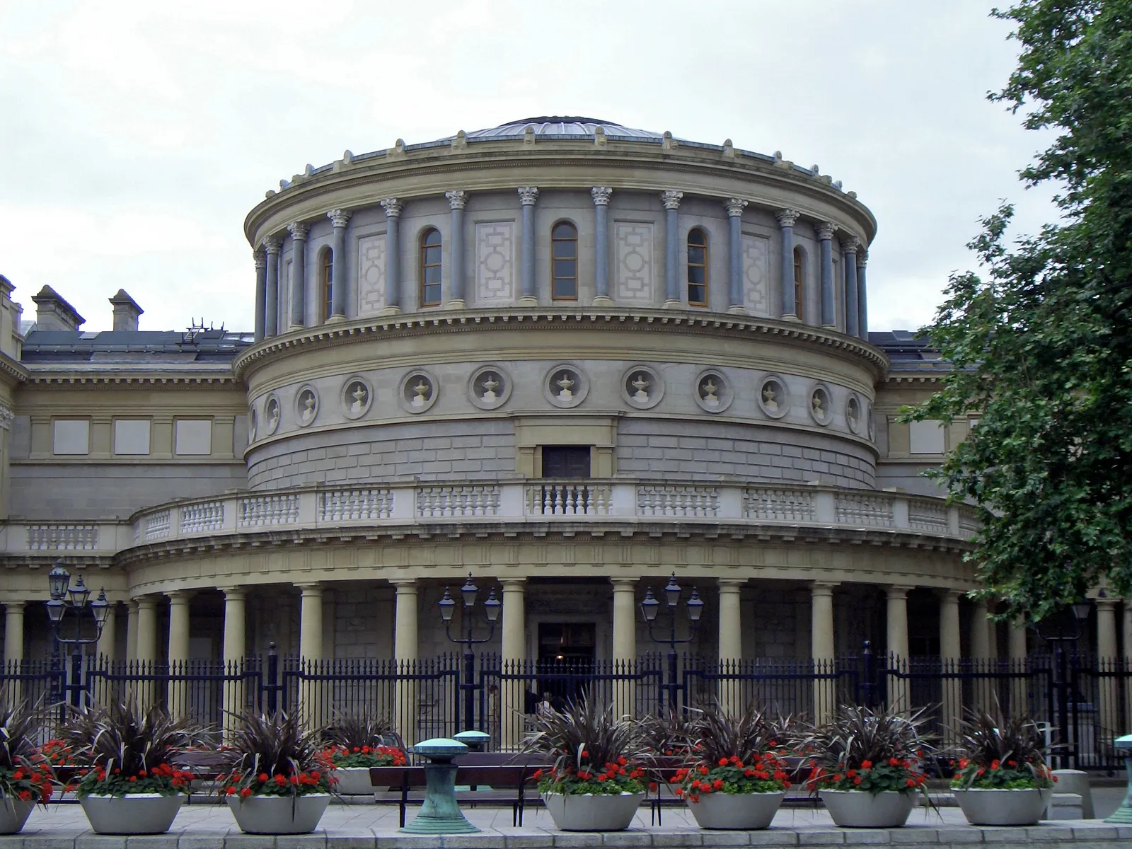 The National Museum of Ireland on Kildare Street in Dublin, a domed Victorian rotunda in pale stone with a colonnaded entrance and railings and flowerbeds along the pavement in front