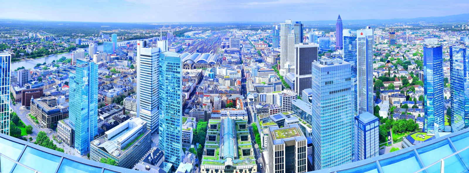 The view from the Main Tower's terrace in Frankfurt, looking down on the roofs of the banking district with glass towers on either side and the city running out to the horizon