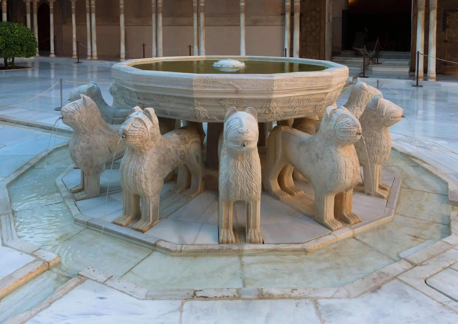 The fountain in the Alhambra's Court of the Lions, a carved marble basin carried on the backs of carved stone lions, with the courtyard's slender columns behind