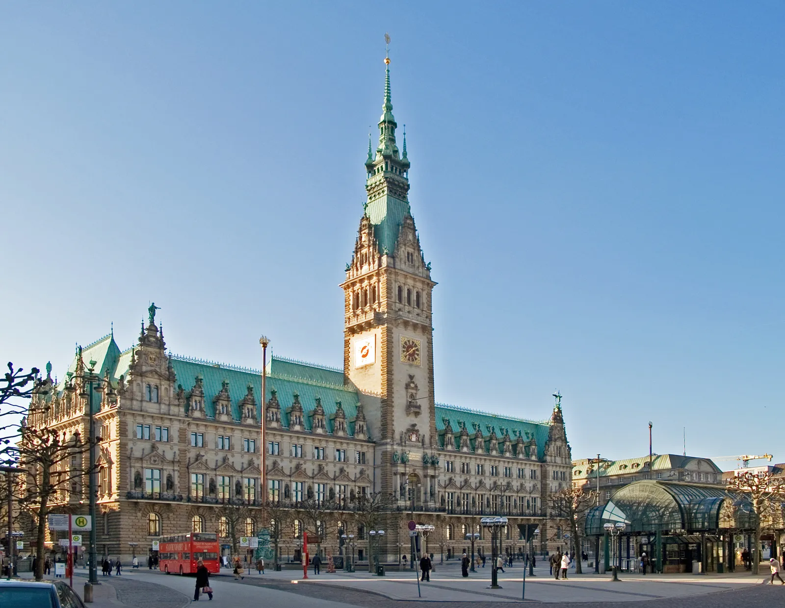 Hamburg City Hall's sandstone facade and green copper roof seen across Rathausmarkt square, with its clock tower at the centre