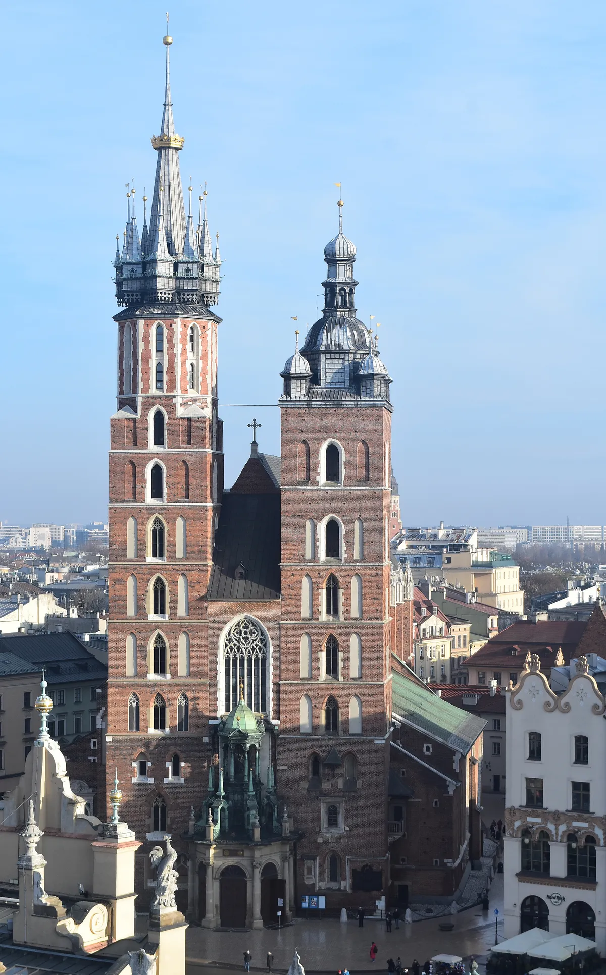 St Mary's Basilica in Kraków, a red brick Gothic church with two towers of different heights, the taller one topped by a spire and a gilded crown, the shorter by a dome