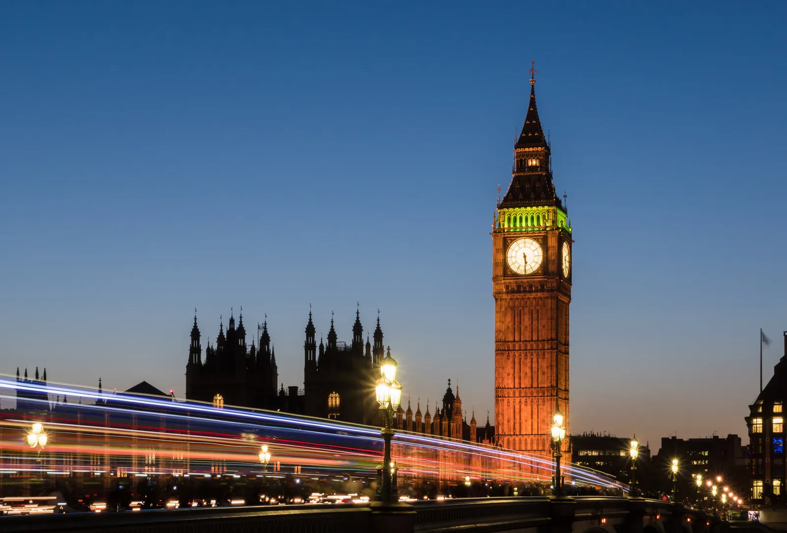 Big Ben and the Houses of Parliament lit up against a clear evening sky in London