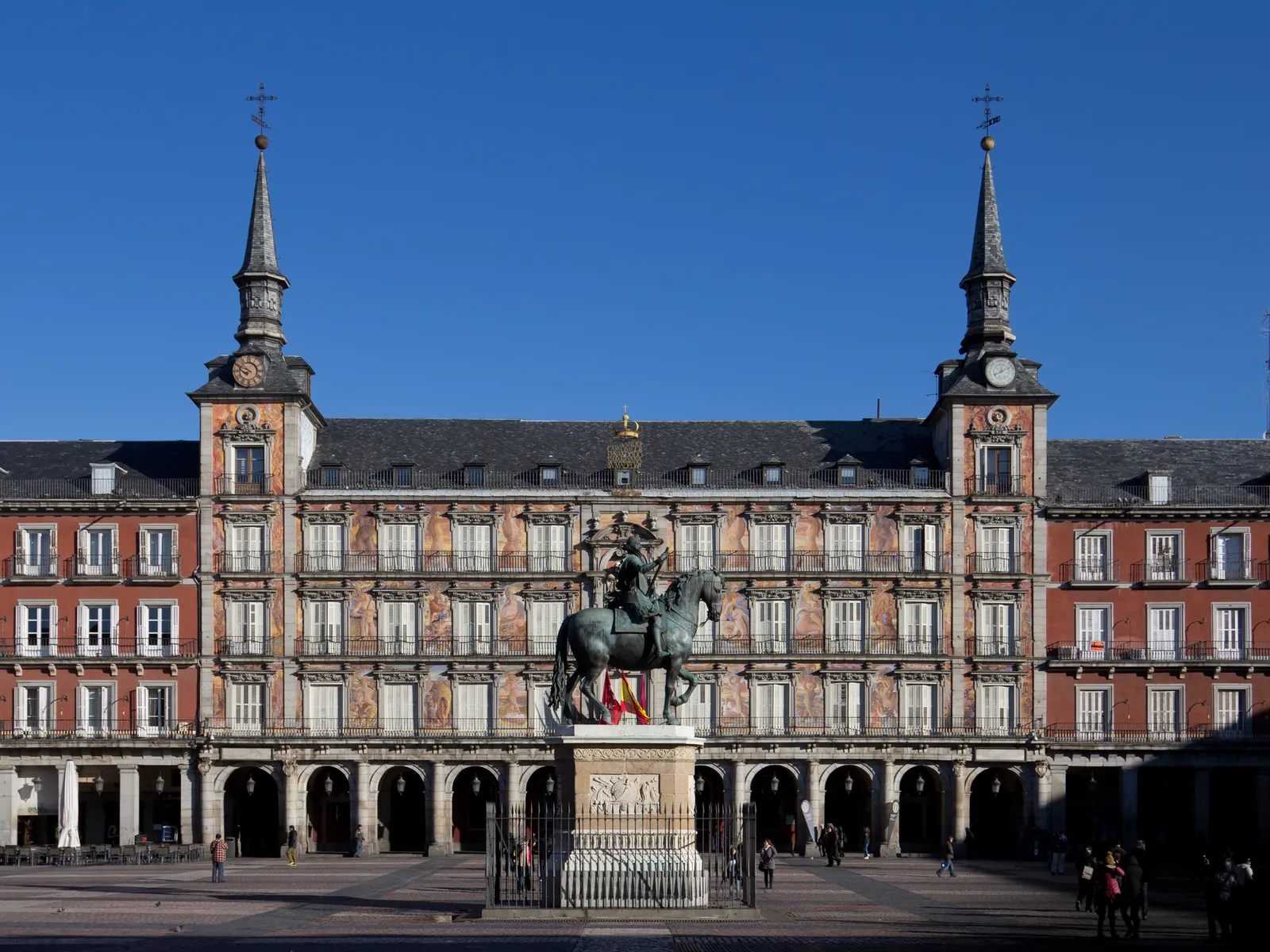 The arcaded facades of Plaza Mayor in Madrid with the equestrian statue of Philip III in the center of the square