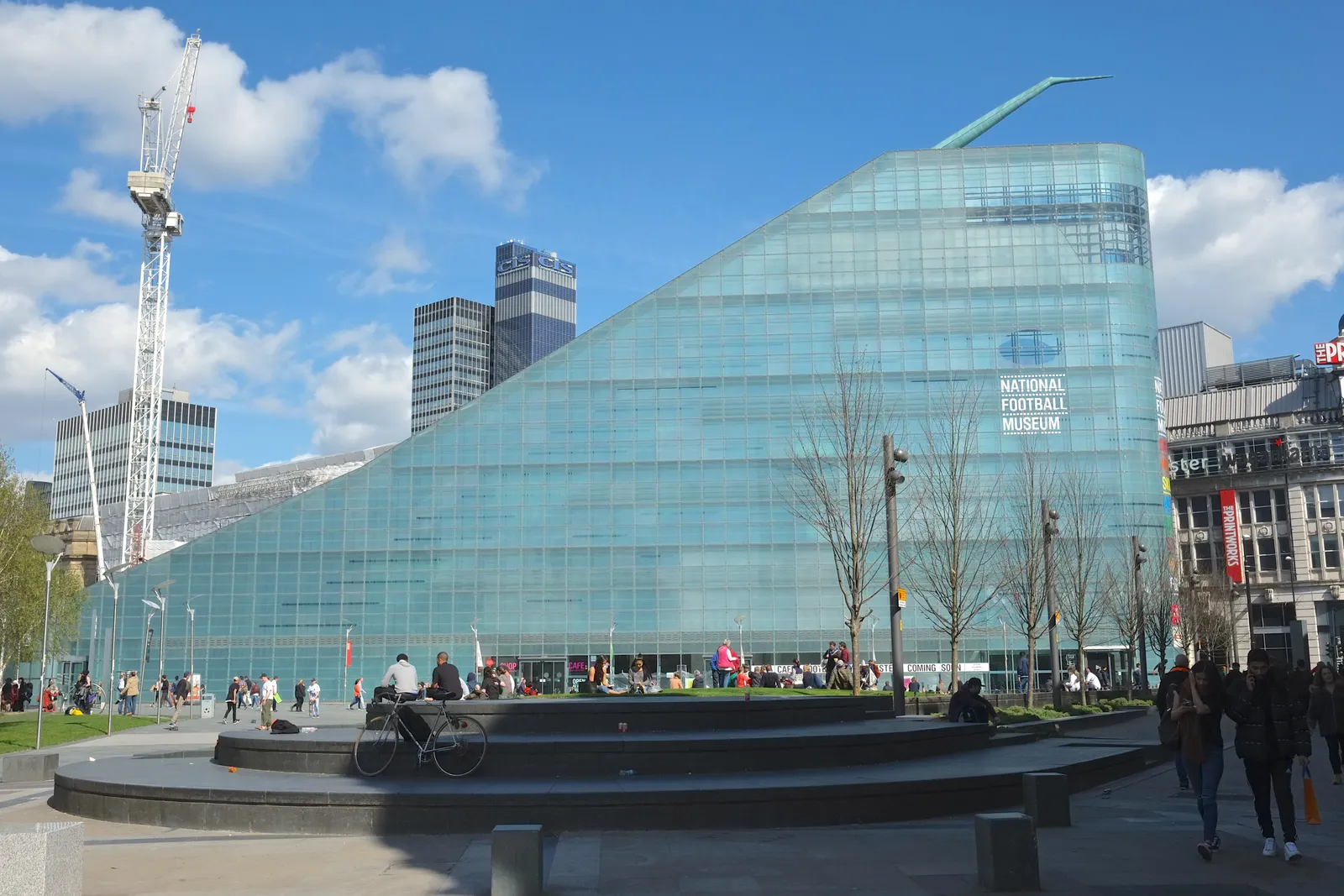 The angular glass Urbis building on Cathedral Gardens in Manchester, now home to the National Football Museum, with its sign visible on the facade