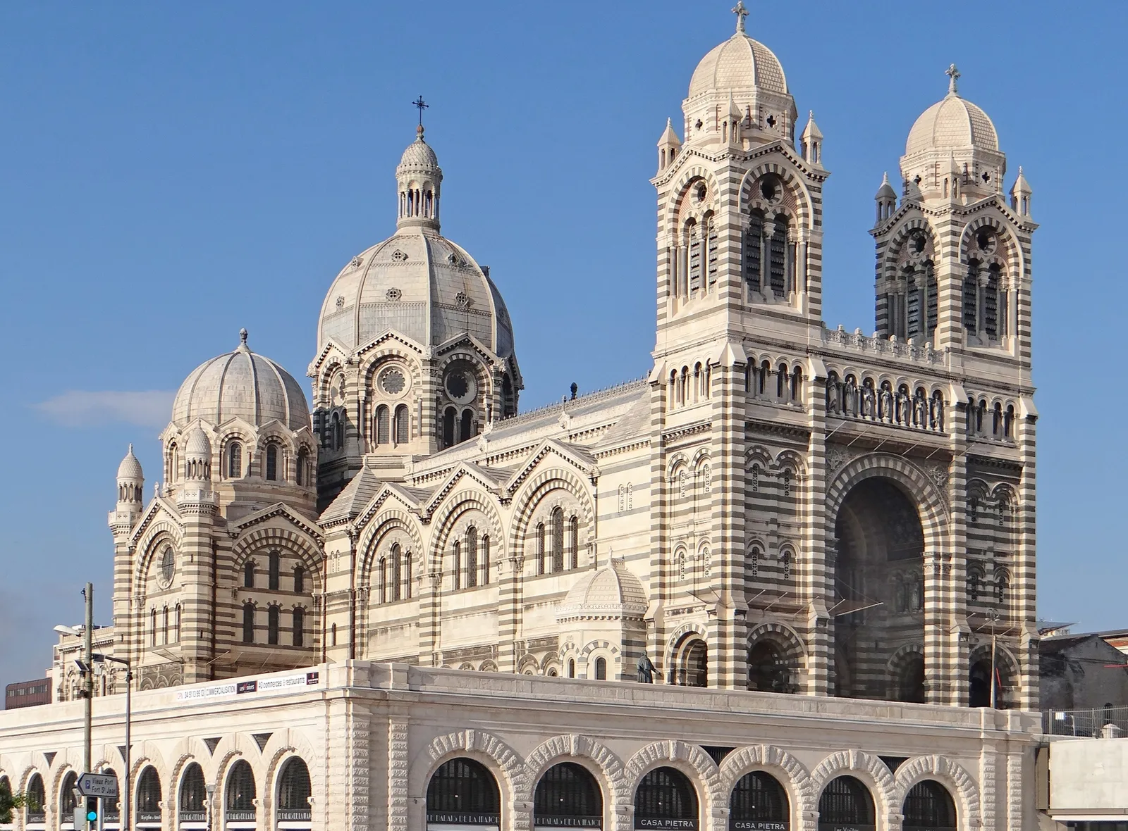 Marseille Cathedral's green-and-white striped stone facade and domes rising against a clear sky above the harbor