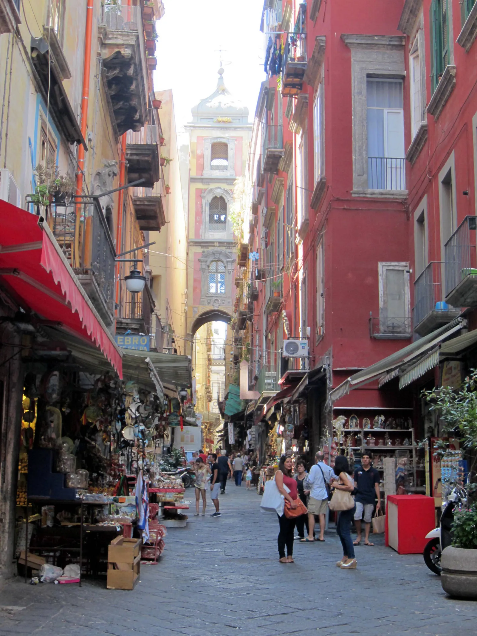 Via San Gregorio Armeno in Naples, a narrow street lined with nativity figure workshops, with a bell tower arching over the far end
