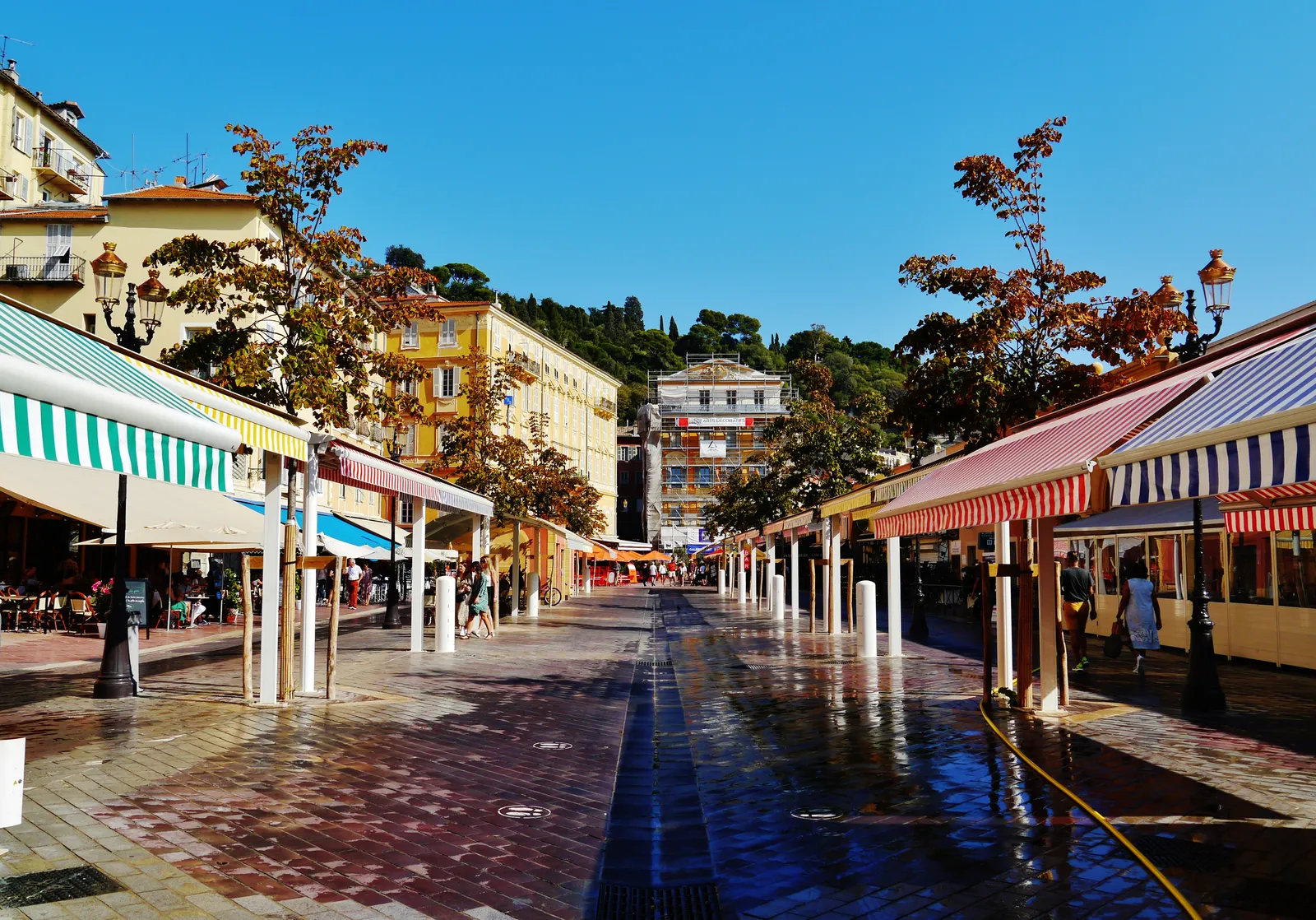 Covered market stalls under striped awnings along Cours Saleya in Nice's Old Town