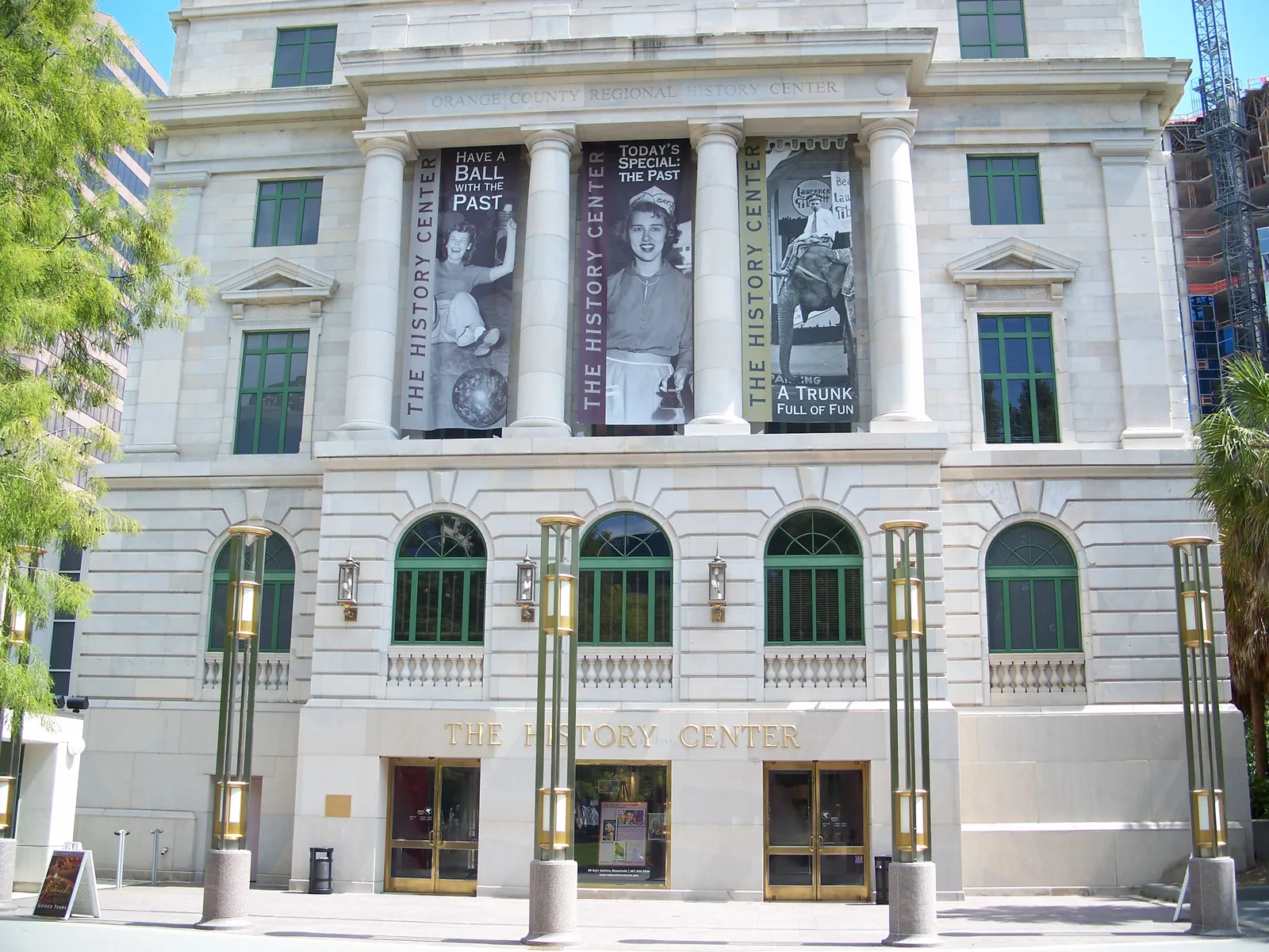 The pale neoclassical front of Orlando's 1927 Orange County courthouse, now the Orange County Regional History Center, with tall banners hung between its columns
