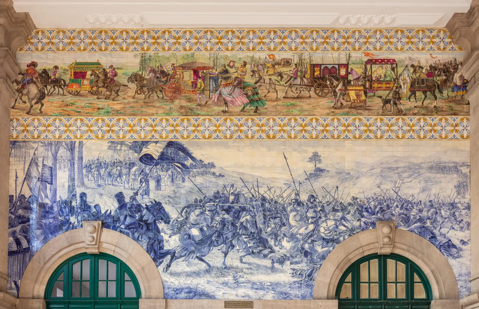 Blue and white azulejo tile panels covering the walls of the entrance hall at São Bento railway station in Porto, showing historical battle and procession scenes