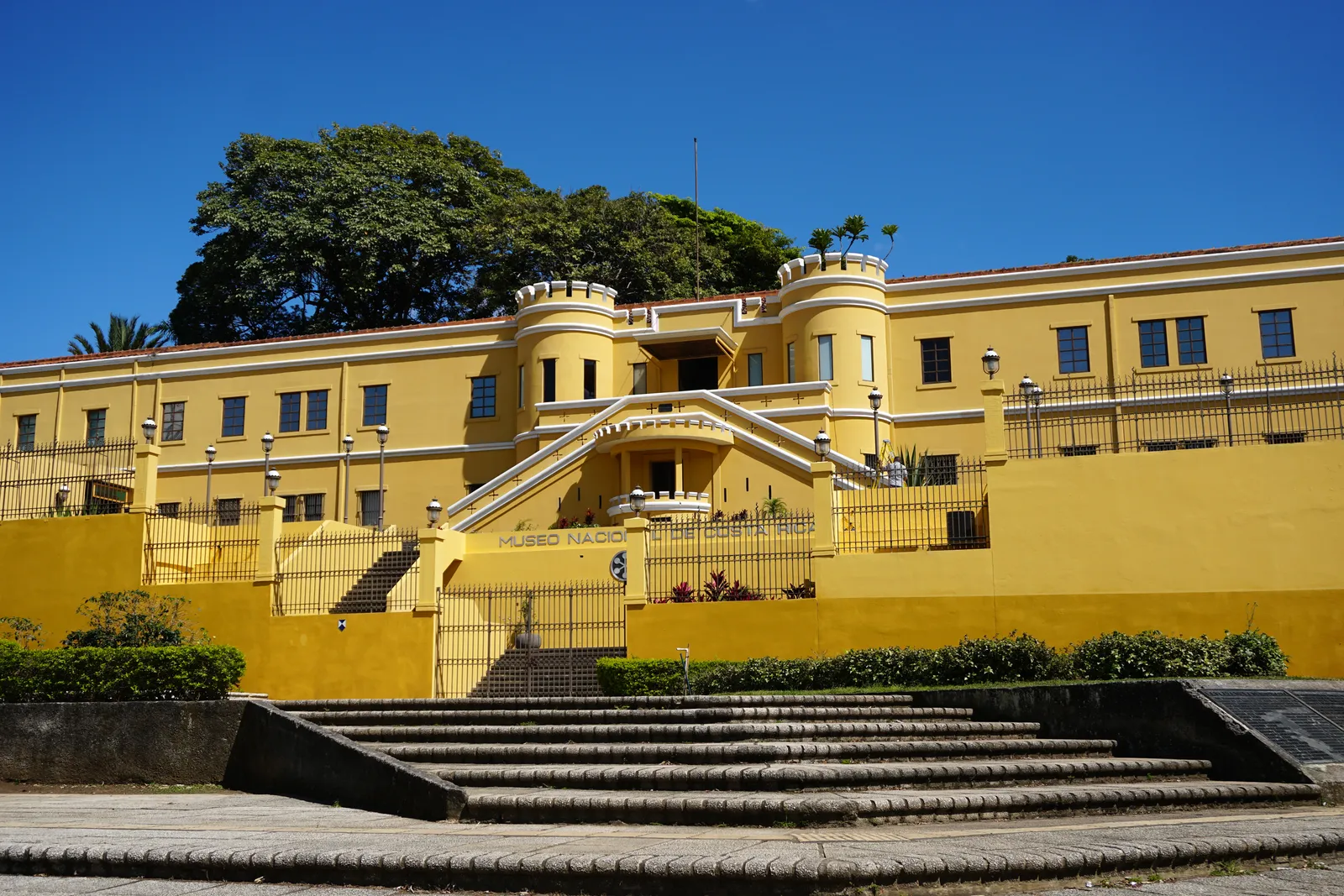 The yellow west wall of the Bellavista barracks in San Jose, now the National Museum of Costa Rica, with a round turret at each end above a broad flight of steps