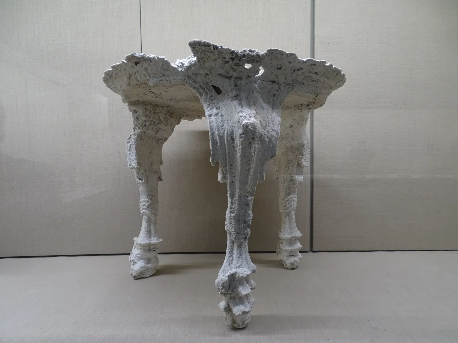 A white plaster cast of a three-legged wooden table from Akrotiri displayed in the Museum of Prehistoric Thera, the shape recovered from the hollow the burnt original left in the ash