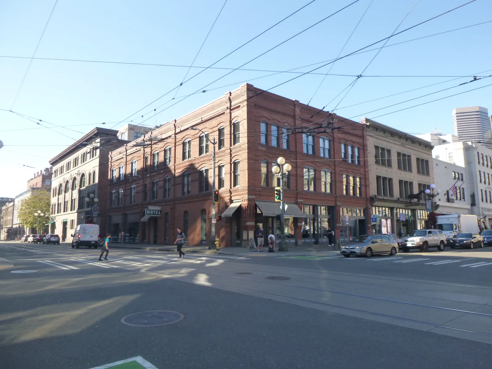 The red-brick Cadillac Hotel building on a corner in Seattle's Pioneer Square, which houses the Klondike Gold Rush museum, with streetcar wires overhead