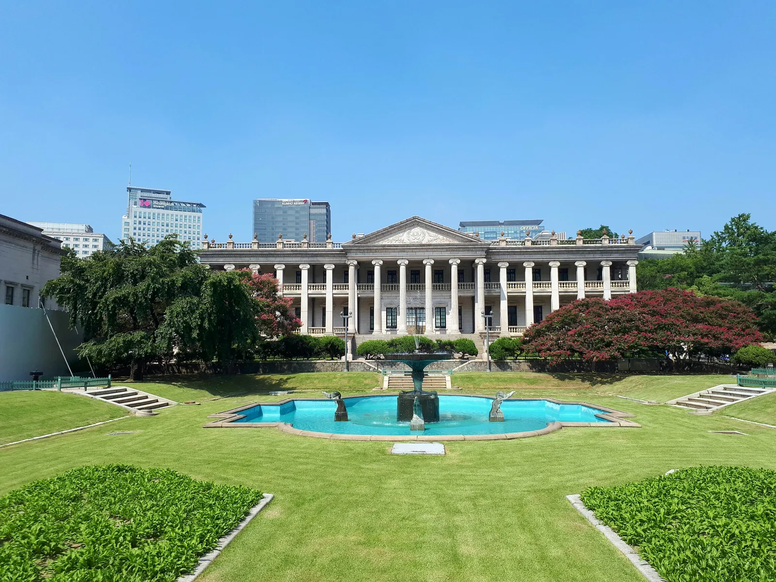 Seokjojeon, the white neoclassical stone hall at Deoksugung Palace in Seoul, with a columned portico behind a lawn and a fountain pool