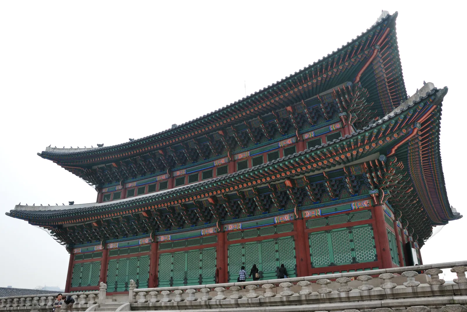 Geunjeongjeon, the throne hall of Gyeongbokgung Palace in Seoul, a two-tiered wooden hall with sweeping tiled roofs and painted eaves above a stone balustrade