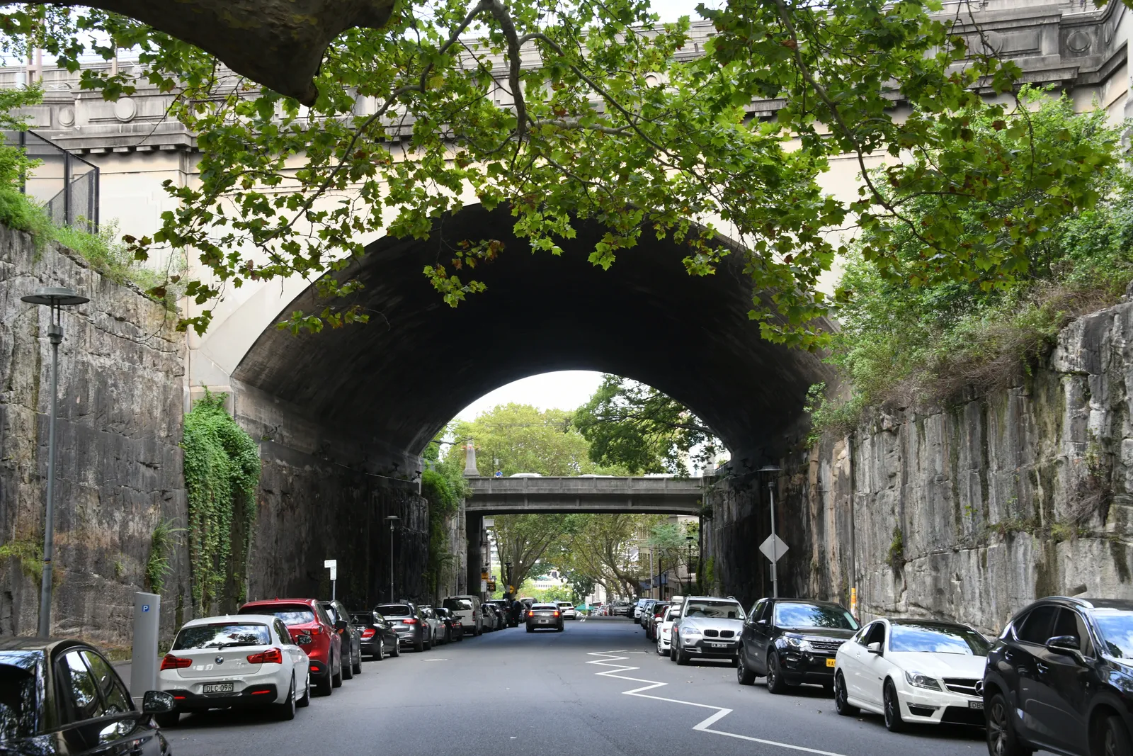 Argyle Street running through the Argyle Cut in The Rocks, Sydney, between walls of cut sandstone and under the arched Cumberland Street bridge