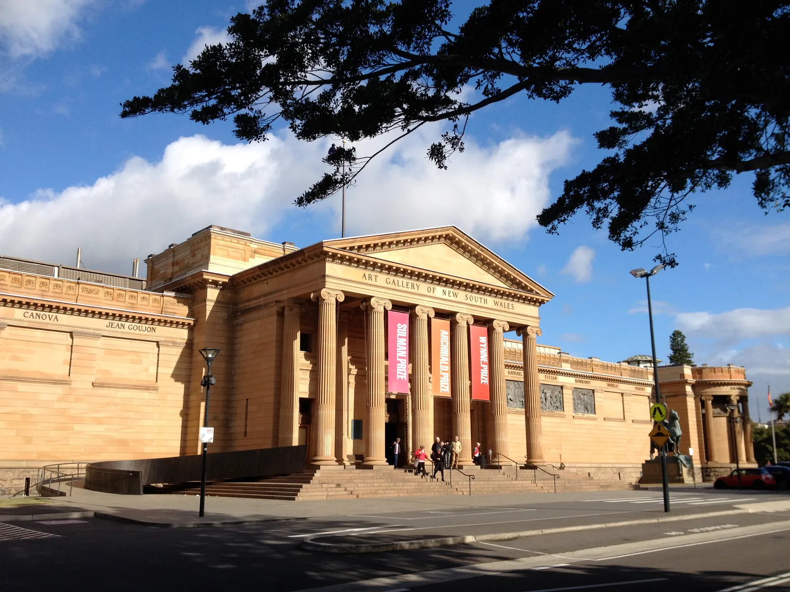 The sandstone columned portico of the Art Gallery of New South Wales on Art Gallery Road, with exhibition banners between the columns