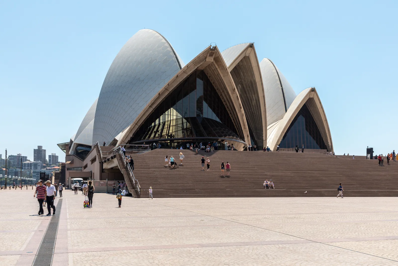 The Monumental Steps rising to the tiled sails of the Sydney Opera House, with people crossing the paved forecourt in front