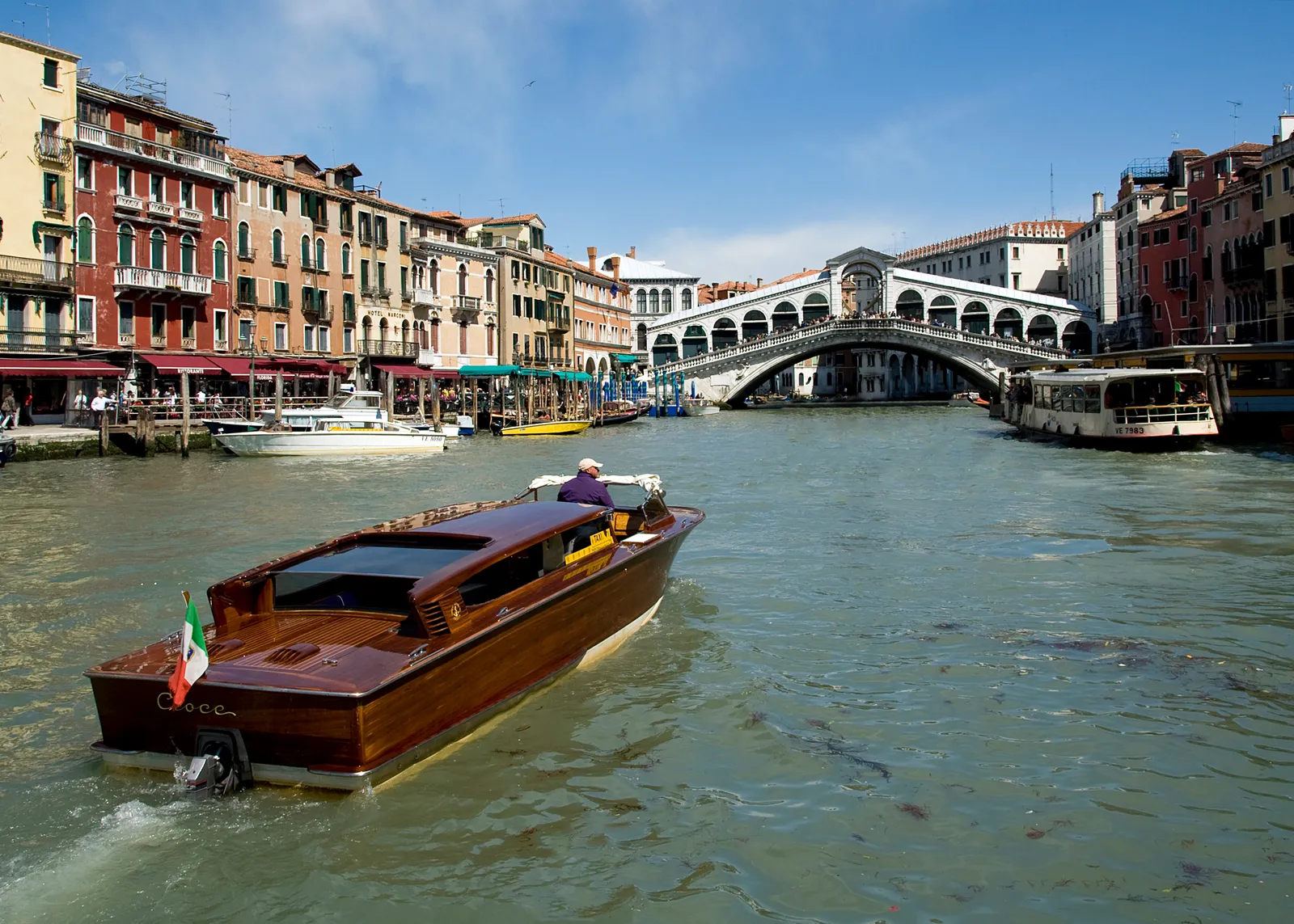 A water taxi passing under the Rialto Bridge on the Grand Canal in Venice