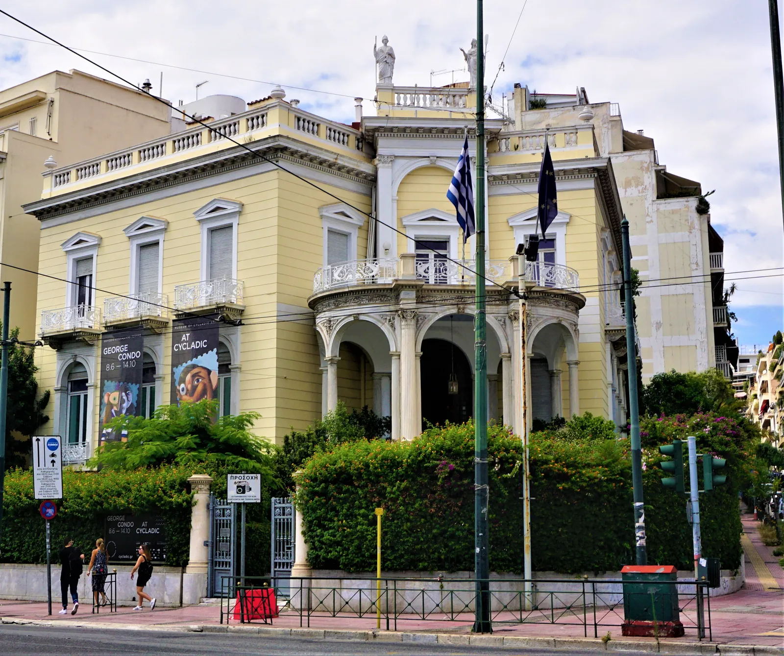 The yellow neoclassical Stathatos Mansion wing of the Museum of Cycladic Art on a corner in Kolonaki, Athens, with exhibition banners hanging on its facade