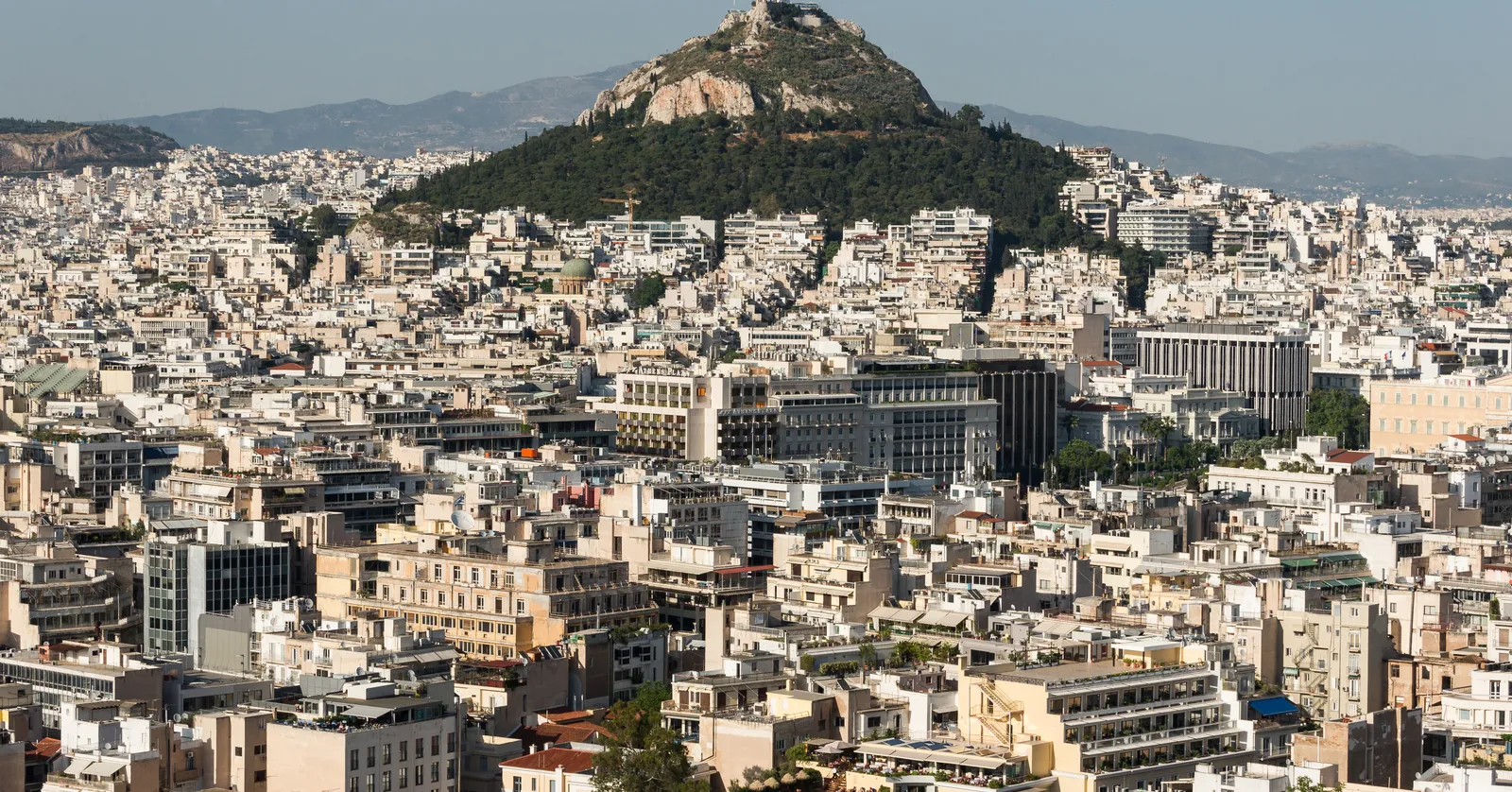 The wooded cone of Lycabettus hill rising abruptly out of the flat sea of apartment blocks in central Athens