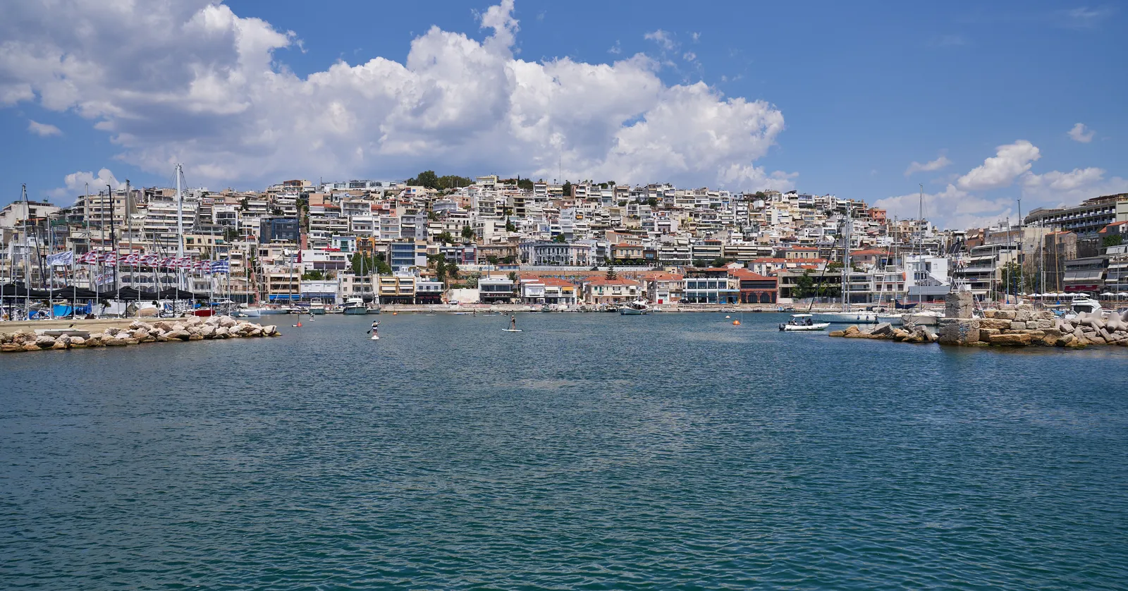 The harbour mouth at Mikrolimano in Piraeus, with the packed houses of the Kastella hillside rising directly behind the waterfront