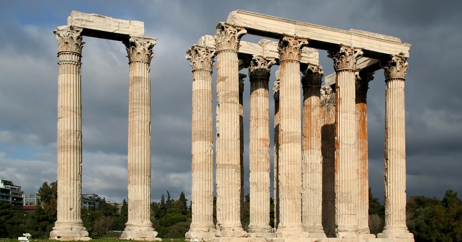 The surviving Corinthian columns of the Temple of Olympian Zeus in Athens standing against a dark cloudy sky