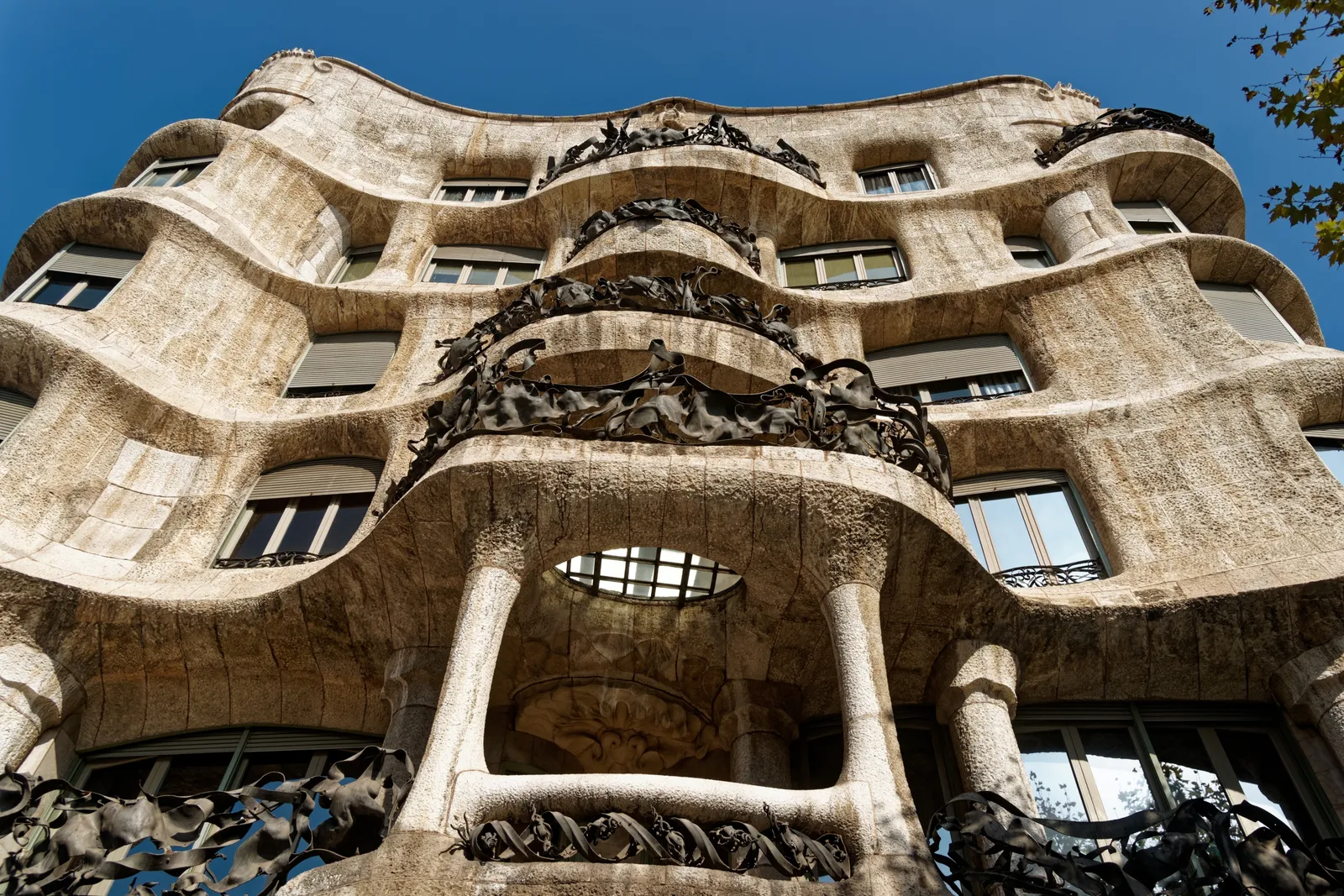 The rippling cream stone front of La Pedrera, Gaudí's Casa Milà, on Passeig de Gràcia in Barcelona, with wrought-iron balconies twisting across it