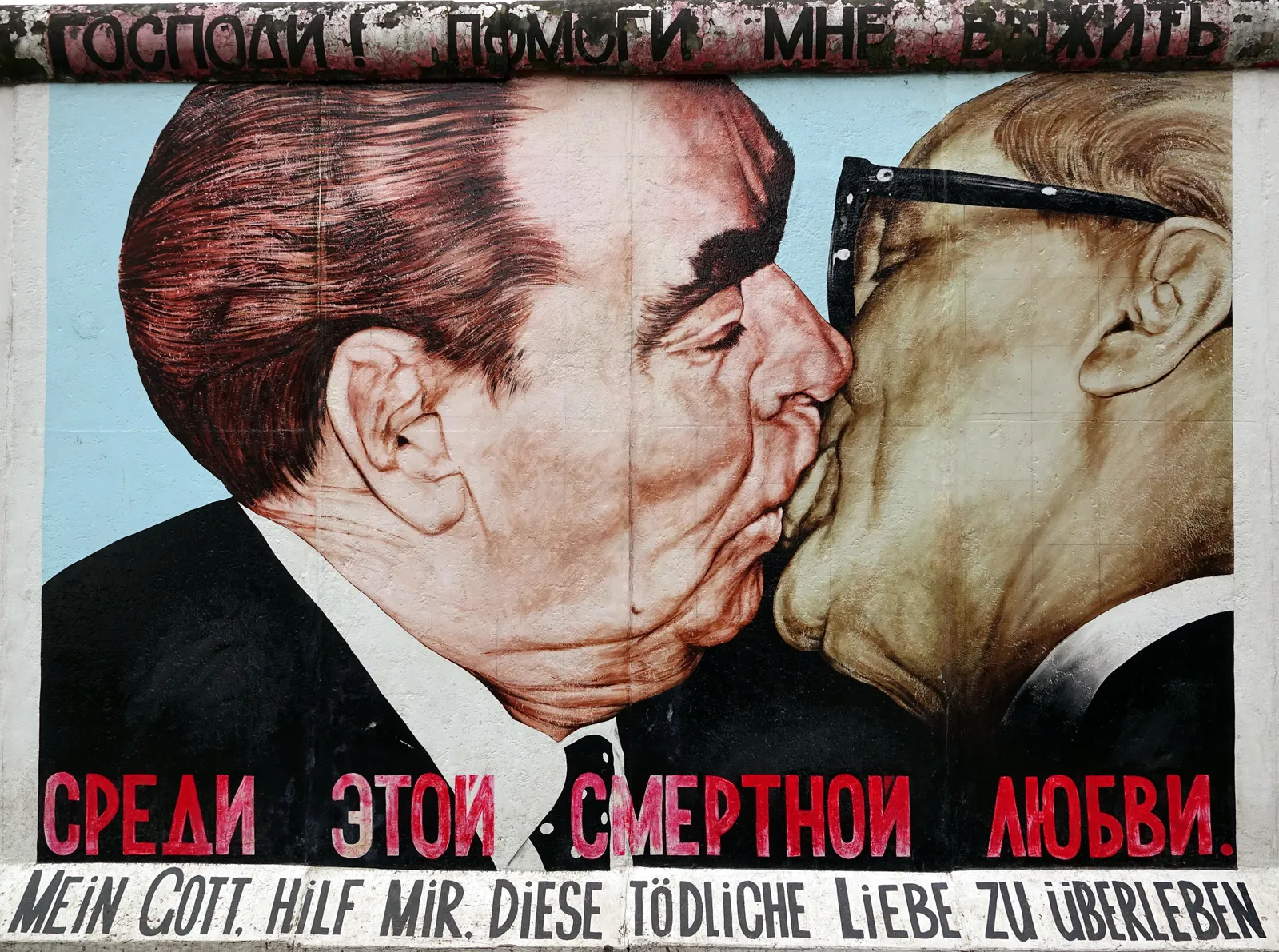 Dmitri Vrubel's mural on the East Side Gallery showing Brezhnev and Honecker kissing, painted from a 1979 photograph, with Russian and German text along the top and bottom of the panel