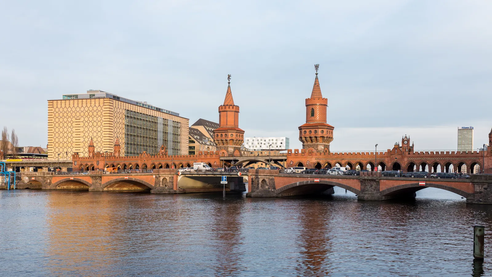 The red brick Oberbaum Bridge across the Spree in Berlin, with its two neo-Gothic towers and double deck carrying road traffic below and the U-Bahn viaduct above
