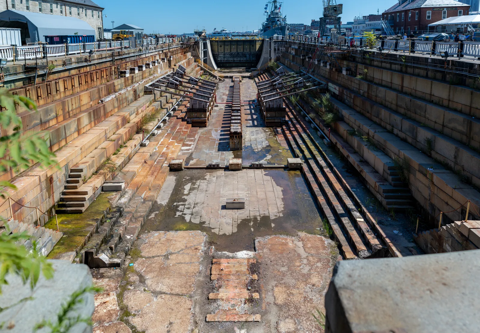 Dry Dock 1 at the Charlestown Navy Yard in Boston, drained to show its stepped granite sides and the line of timber keel blocks running along the floor