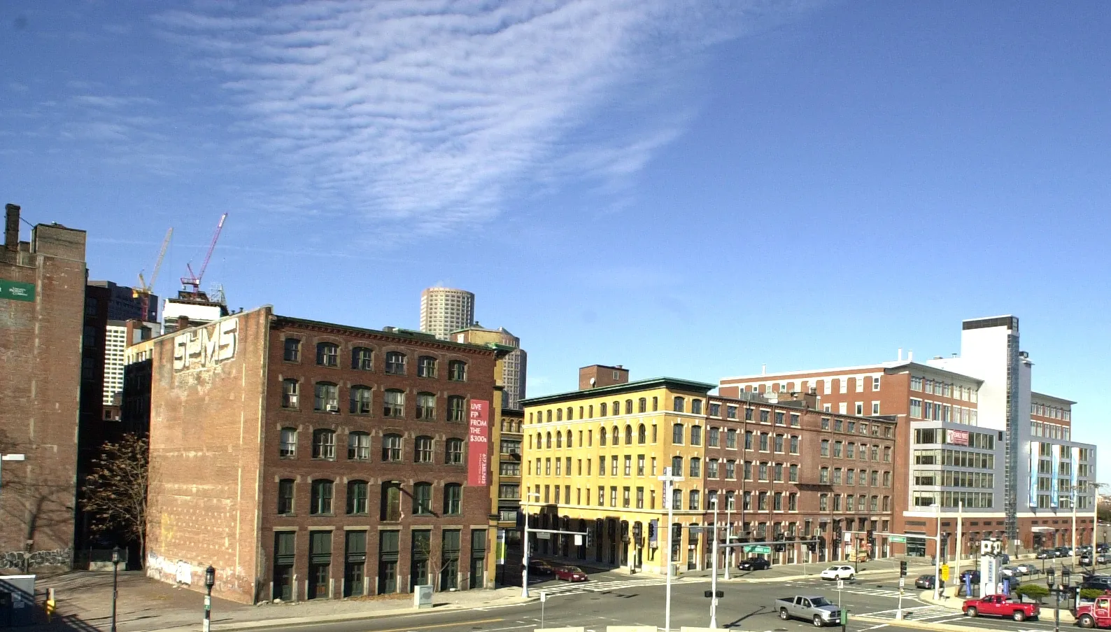 Red-brick warehouse blocks in Boston's Fort Point Channel Historic District, an ochre-fronted block beside them and Financial District towers rising behind