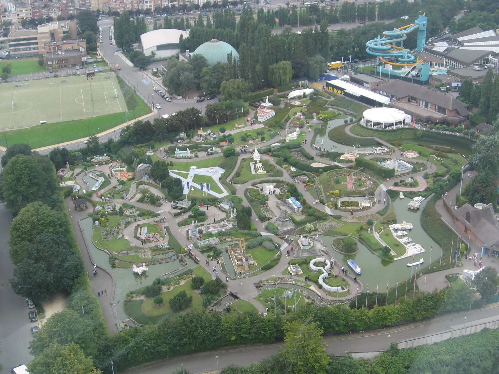 Mini-Europe in Brussels seen from above, winding paths threading between hundreds of scale models of European buildings laid out among trimmed lawns and hedges