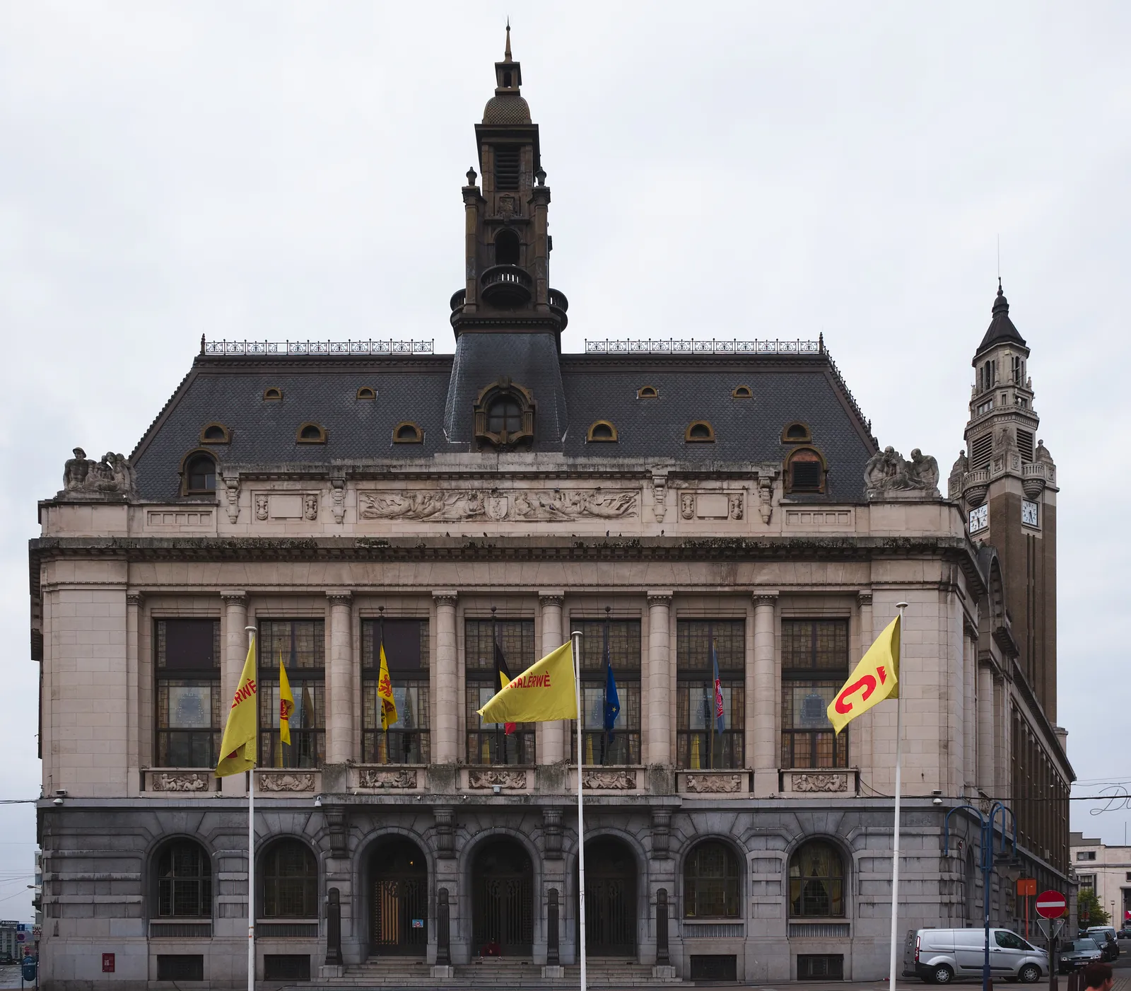 Charleroi town hall on the Place Charles II, a pale stone front with flags along its balcony and the square belfry tower rising beside it