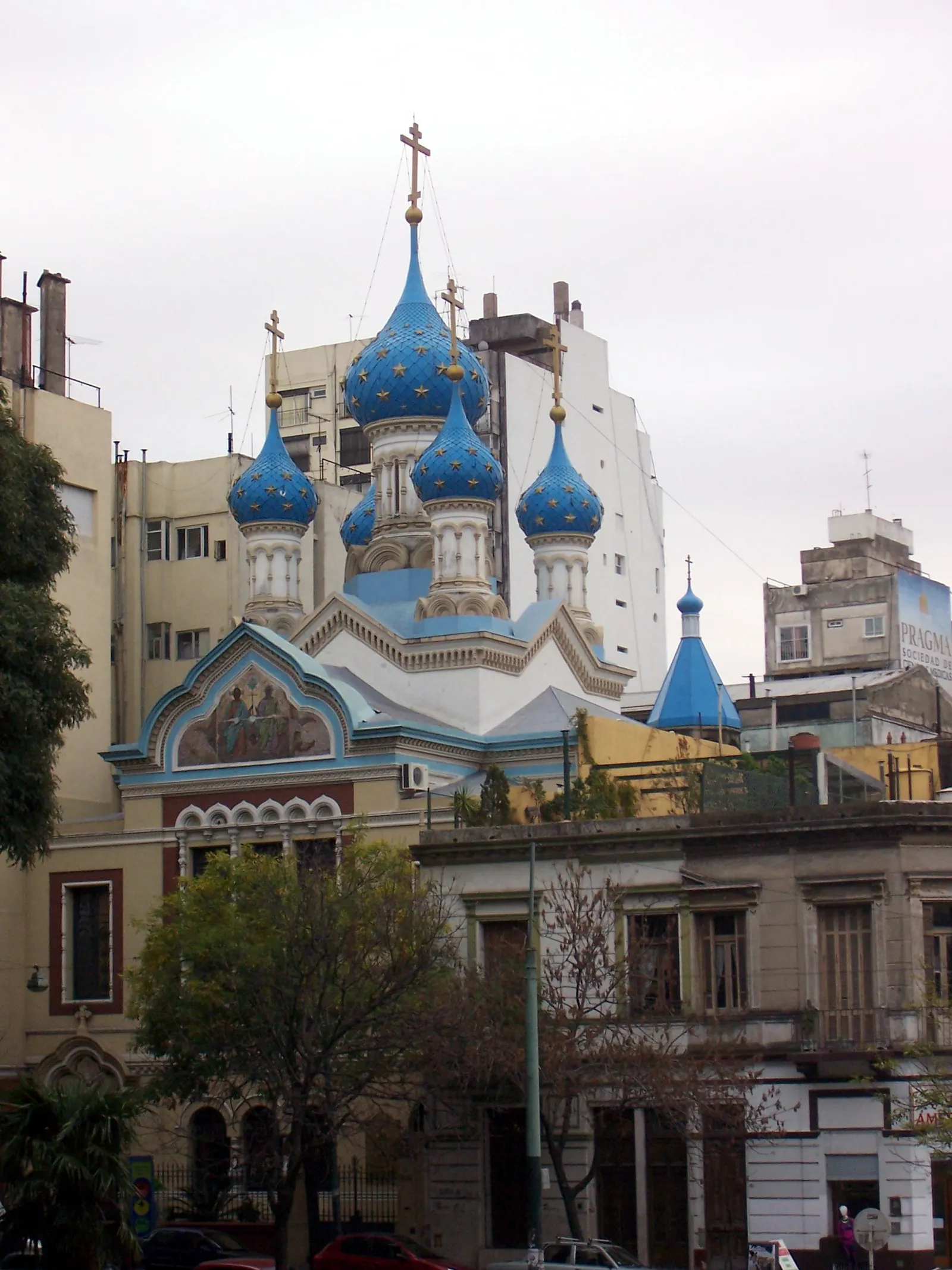 The Russian Orthodox Cathedral of the Most Holy Trinity in Buenos Aires, its cluster of bright blue onion domes topped with gold crosses standing above the white walls of the church and the apartment buildings behind it