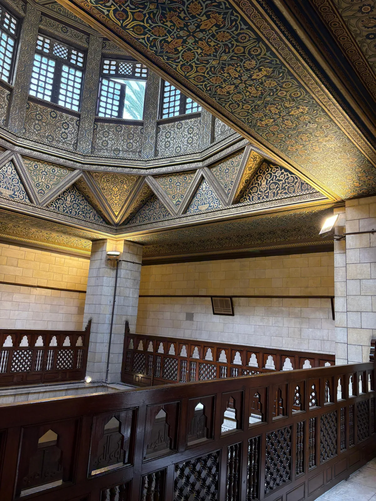 The painted and gilded wooden ceiling above the Nilometer shaft on Rhoda Island, with a carved timber railing running around a gallery that looks down into the well below