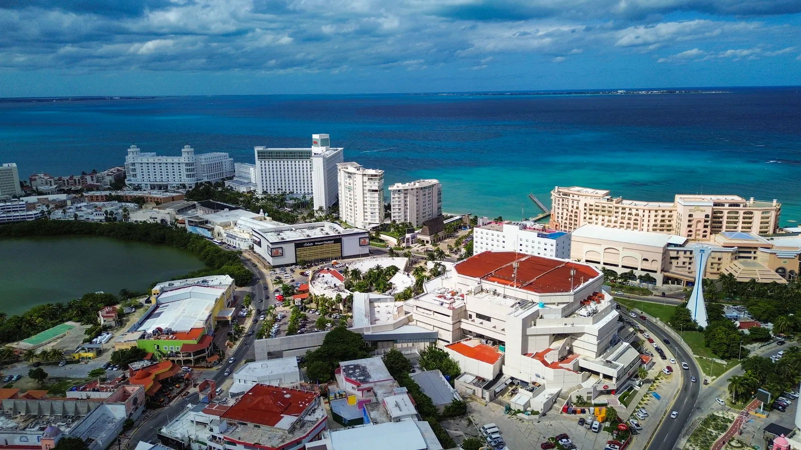 Punta Cancún from the air, hotel blocks and a domed entertainment venue packed onto the narrow point with the Nichupté lagoon on one side and open Caribbean water on the other