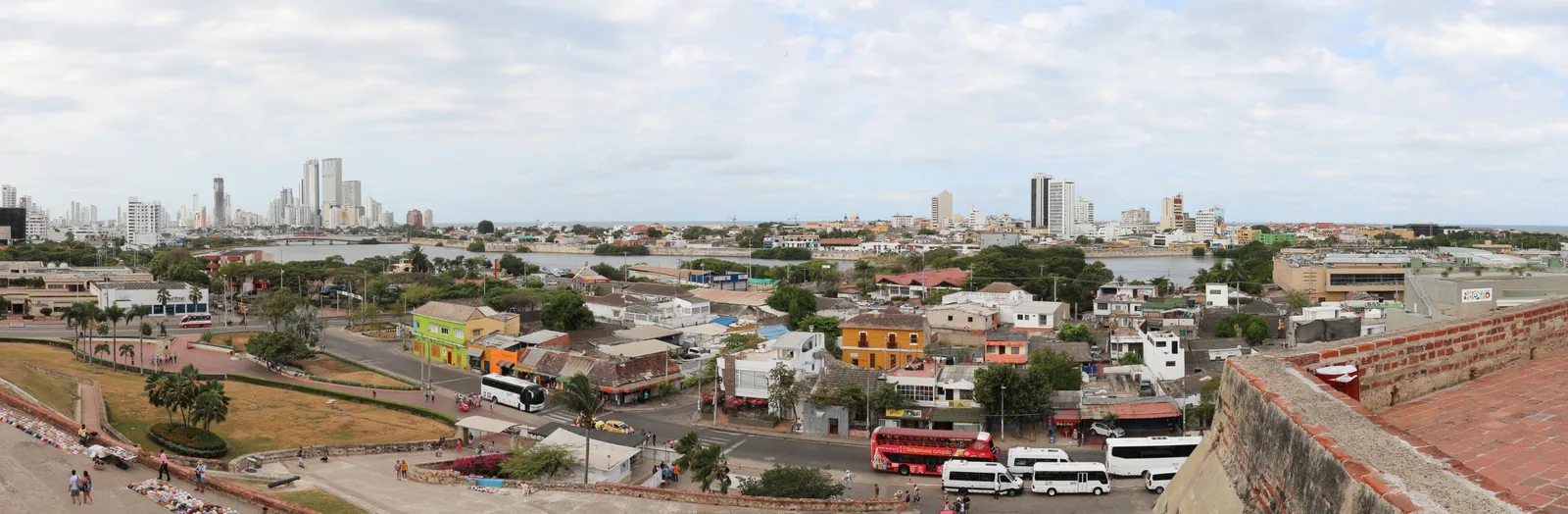 A wide panoramic view of Cartagena's rooftops, streets and distant skyline seen from the upper terraces of Castillo San Felipe de Barajas