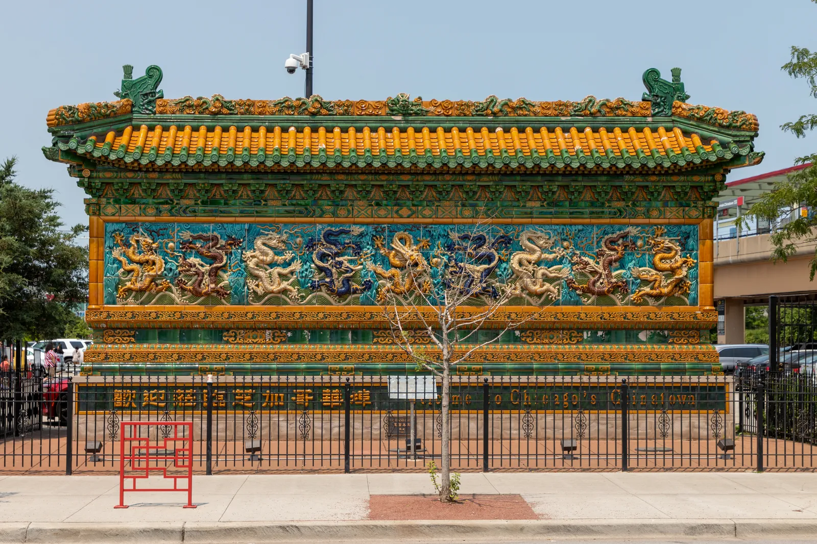 The Nine Dragon Wall in Chicago's Chinatown, a free-standing screen of glazed tile under a yellow and green tiled roof, with nine colored dragons across its face