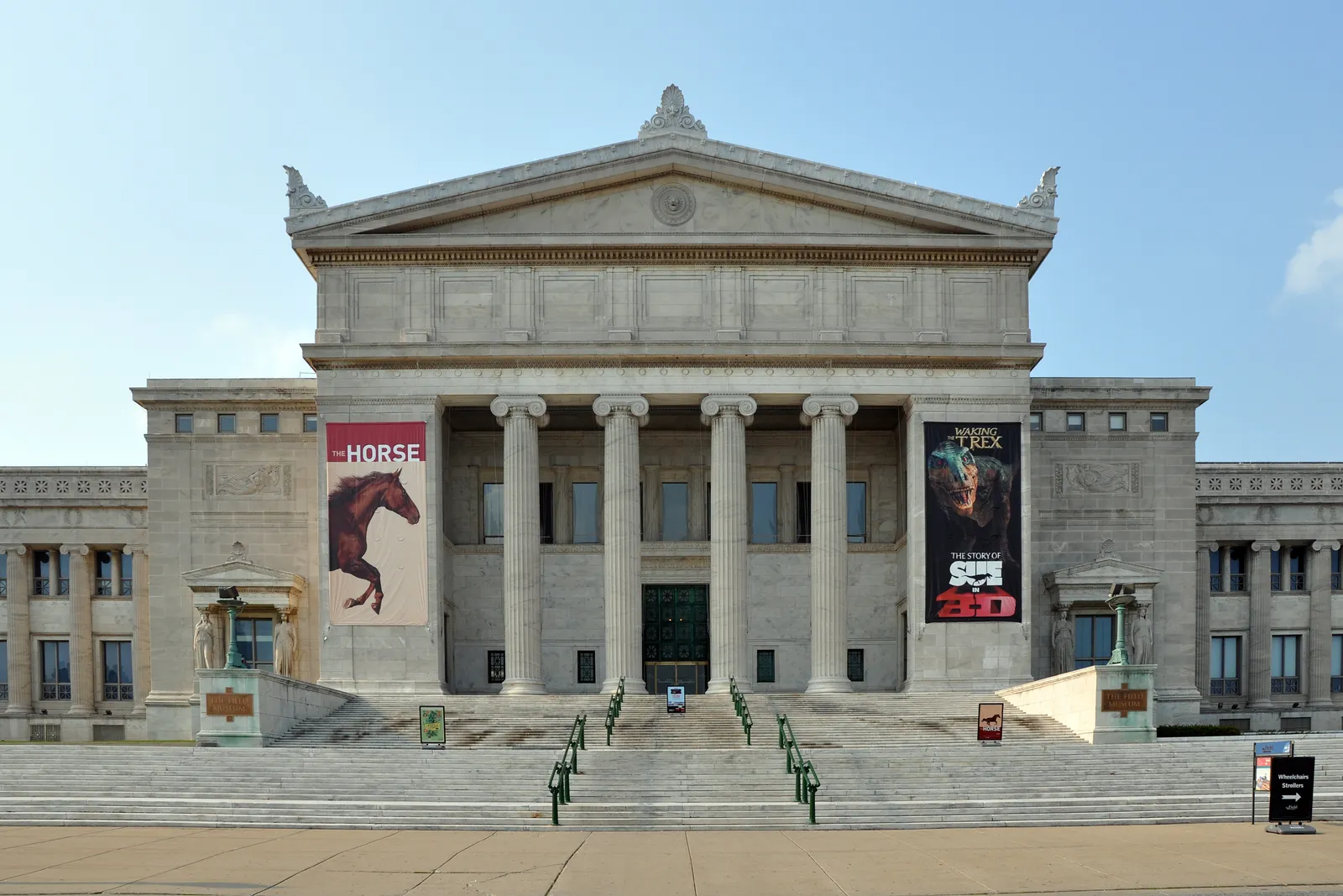 The Field Museum in Chicago seen straight on from its terrace, a wide limestone building with a columned portico, a pediment and long flights of steps running up to the doors