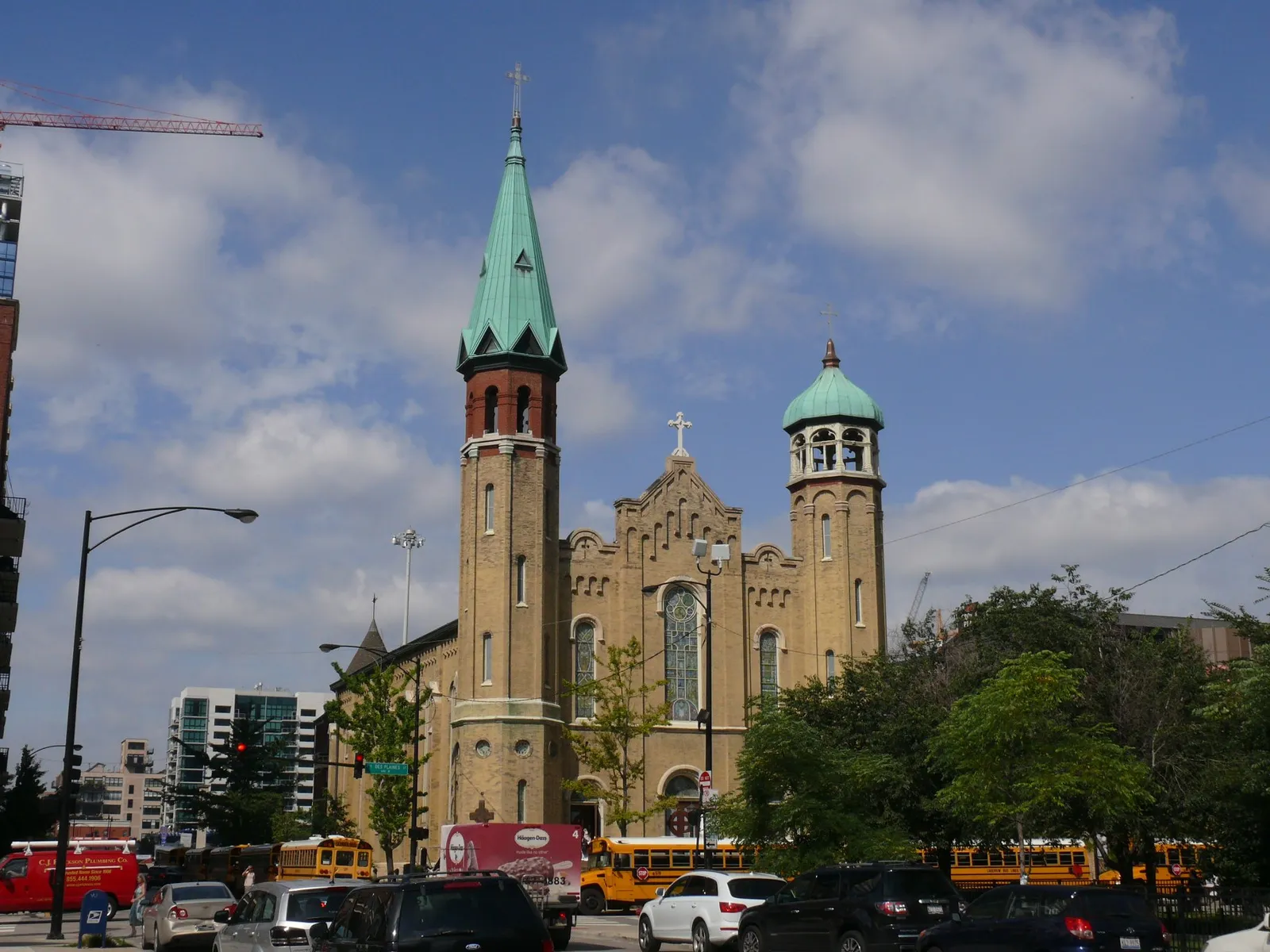 Old St. Patrick's Church in Chicago's West Loop, a yellow brick church with two mismatched octagonal spires, one pointed and one domed, both topped in green copper