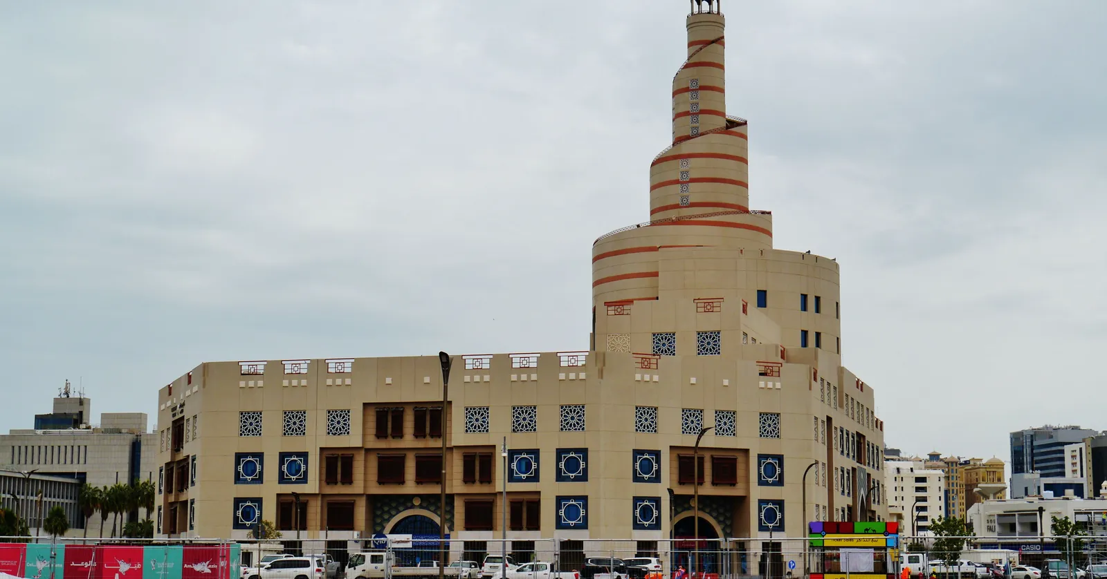The Fanar Islamic Cultural Centre in Doha, a sand-coloured block patterned with blue tilework under a tall spiral minaret wound with a ramp