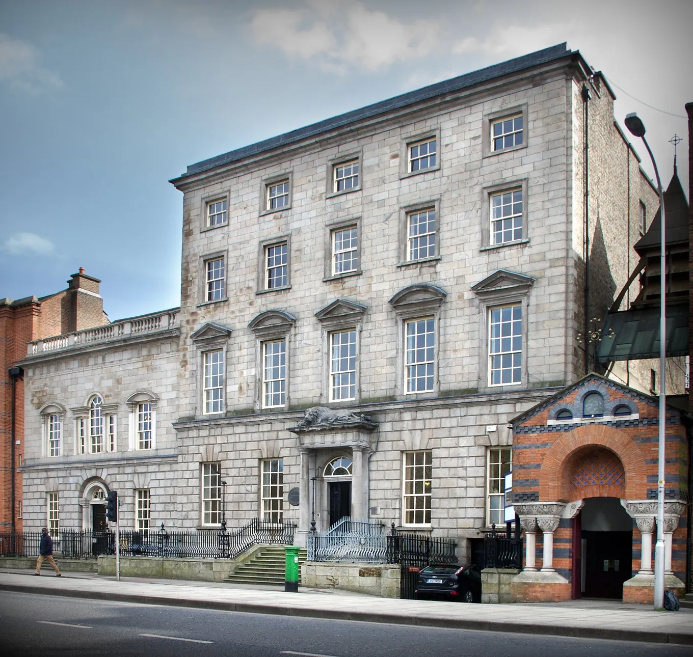 Newman House on St Stephen's Green in Dublin, a tall grey stone Georgian townhouse of five bays with a pedimented doorway reached by steps, standing in a terrace on the street
