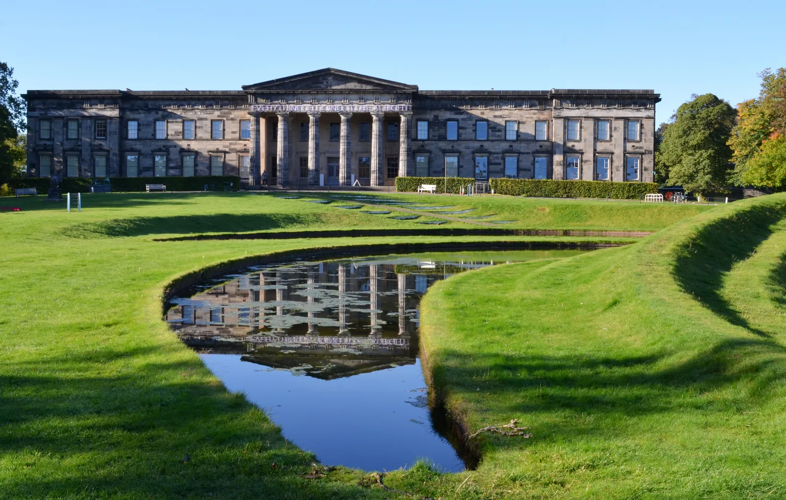 The neoclassical Modern One gallery on Belford Road in Edinburgh behind Charles Jencks' Landform, a stepped serpentine grass mound wrapped around crescent-shaped pools