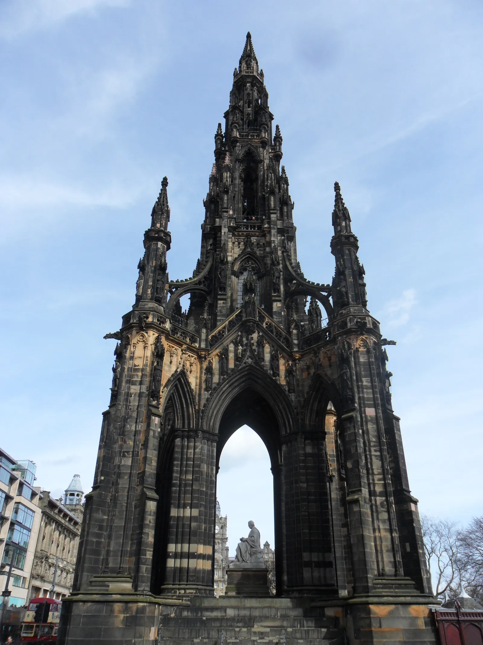 The Scott Monument in Edinburgh's Princes Street Gardens, a blackened Gothic tower of open arches and pinnacles rising over the white marble statue of Walter Scott beneath it