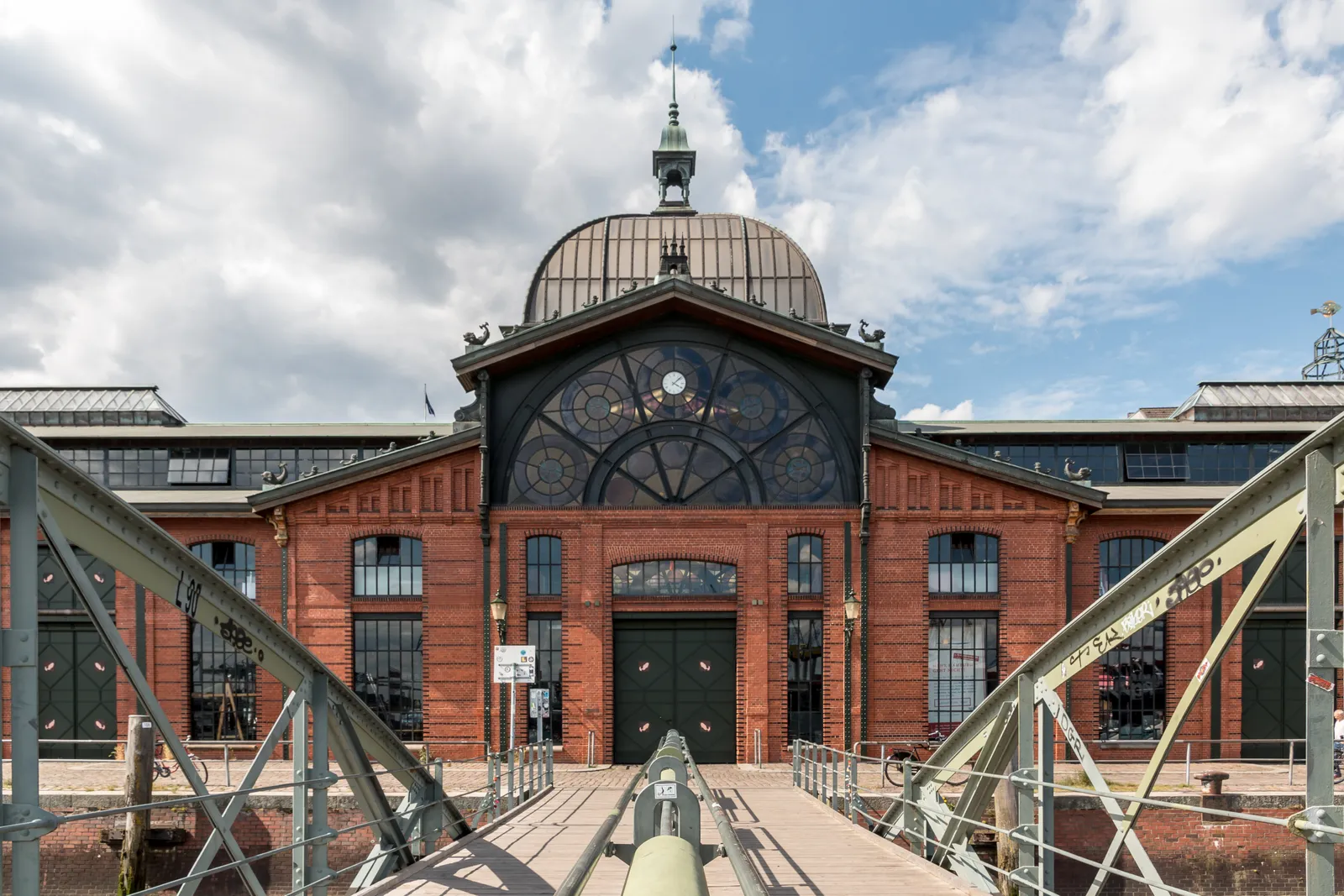 The red-brick front and glazed dome of Hamburg's fish auction hall, photographed head-on from the footbridge that leads to its doors