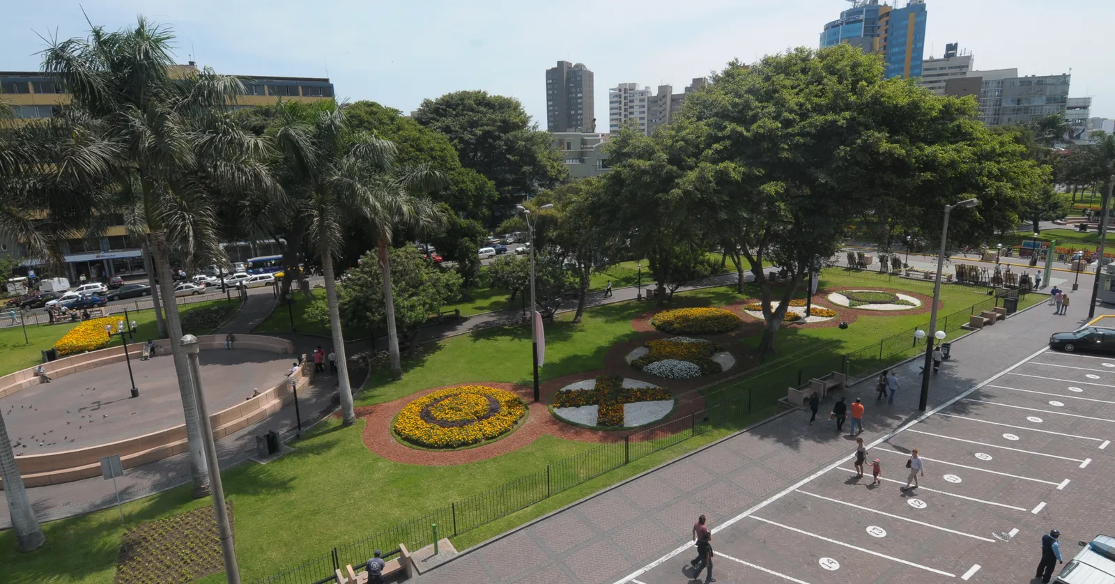 Parque Kennedy in Miraflores seen from above, with circular flower beds, palms and mature trees ringed by the traffic and apartment towers of central Miraflores