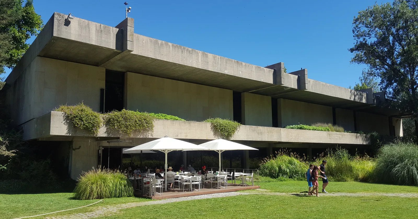The low concrete slabs and planted terraces of the Calouste Gulbenkian Museum building in Lisbon, seen across the lawn of its garden